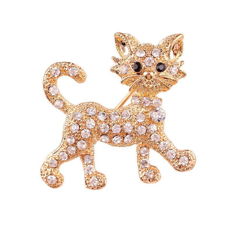 A diamond encrusted gold cat brooch on a white background