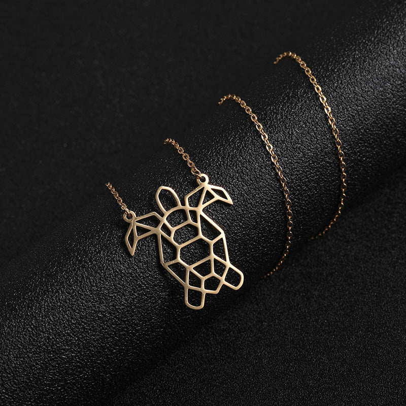 A gold turtle necklace coiled around a black foam cylinder