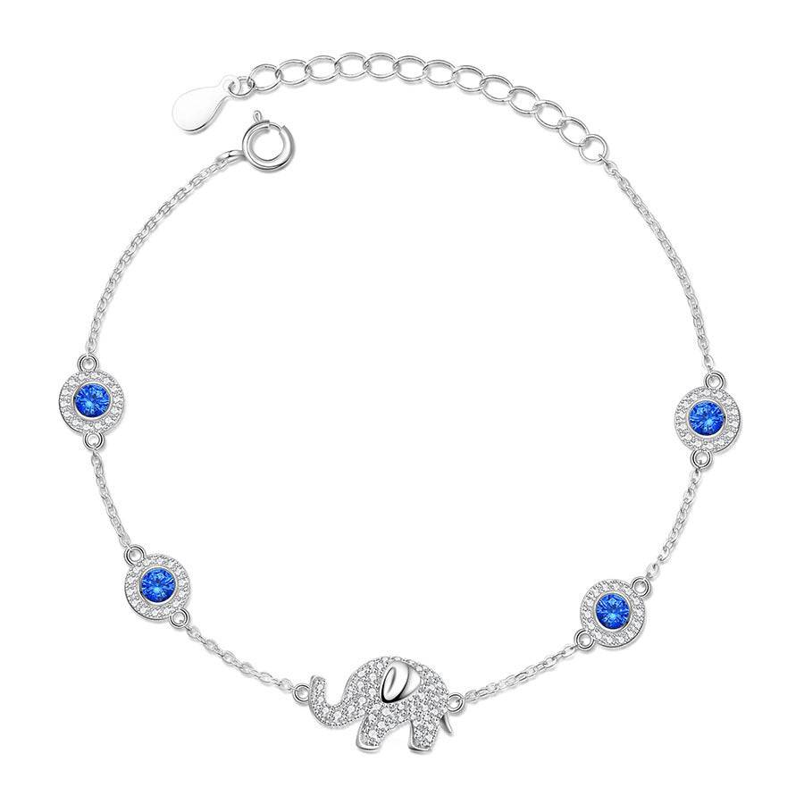 A silver bracelet with blue stones in it and an elephant pendant.