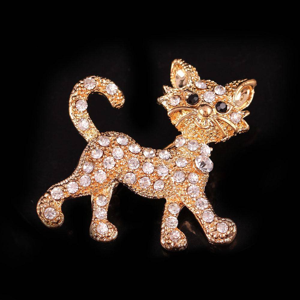 A diamond encrusted gold cat brooch on a black background 