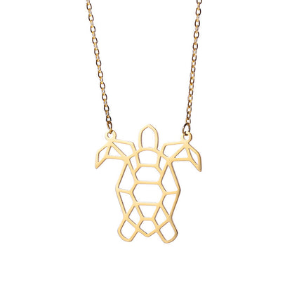 A gold colored turtle necklace on a white background 