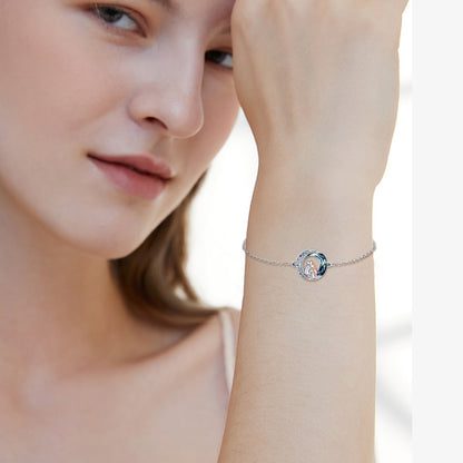 The sterling silver dog bracelet on the wrist of a woman